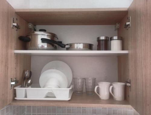 a shelf with pots and pans and cups in a kitchen at Acropolis studio with breathtaking city view in Athens