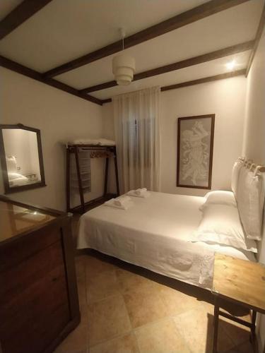una camera con un letto bianco e un tavolo di N'DU SCARRON Casa nel centro storico con panorama ad Accettura