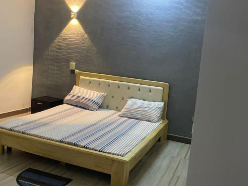 1 cama con 2 almohadas en una habitación en Les Appartements Junior, en Cotonou