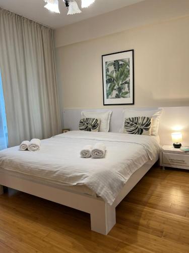 a bedroom with a large white bed with towels on it at Copou Central Linden Suite in Iaşi