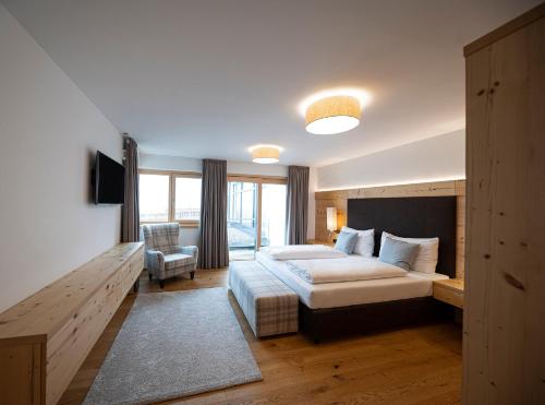 Habitación de hotel con cama y silla en Lakeside Luxury Apartments en Zell am See
