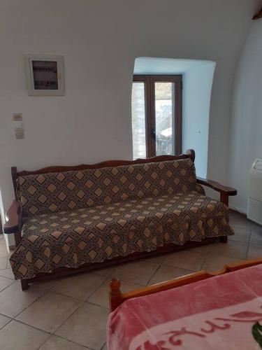 un sofá sentado en la esquina de una habitación en klisounis house, en Leonidio