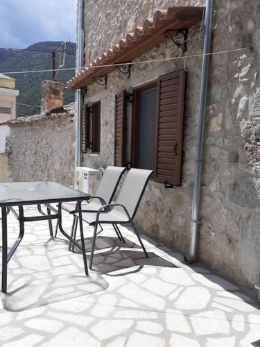 2 sillas y una mesa en el patio en klisounis house, en Leonidio