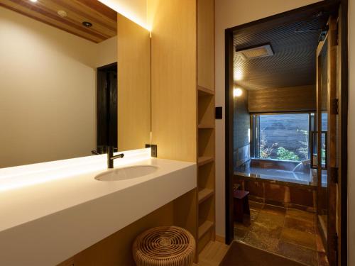 a bathroom with a sink and a window at Unzen Miyazaki Ryokan in Unzen