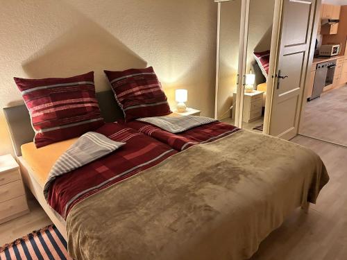 sypialnia z dużym łóżkiem z czerwonymi poduszkami w obiekcie Beautiful holiday apartment in Stolpe w mieście Stolpen