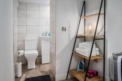 a small bathroom with a white toilet and towels at Coppergate Mews Apt 1 Stylish 2 bed 2 bath apartment private entrance Doncaster in Doncaster