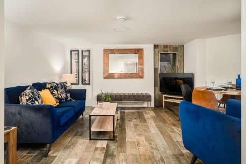 a living room with blue couches and a table at Coppergate Mews Doncaster 2-bed with private patio in Doncaster