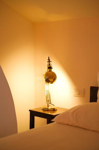 a lamp sitting on a table next to a bed at Old Stone House in Bari