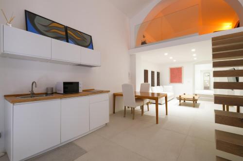 uma cozinha e sala de jantar com armários brancos e uma mesa em Old Stone House em Bari