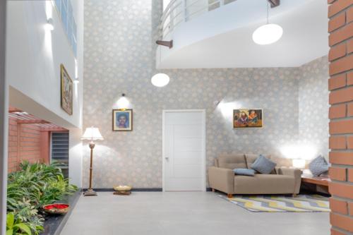 a living room with a couch and a door at Ixora Suites in Bengaluru