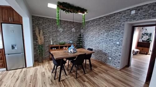a dining room table with chairs and a brick wall at Stone House in Lagoa