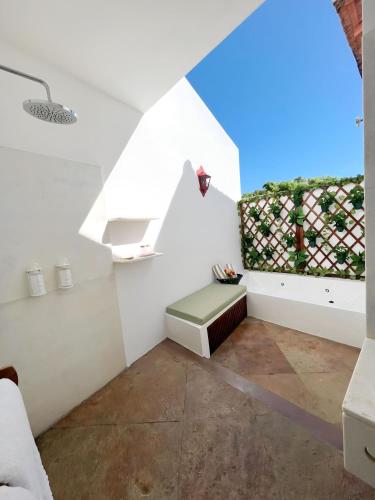a white room with a bench and a window at Casa de St. Antônio Hotel Boutique in Parnaíba