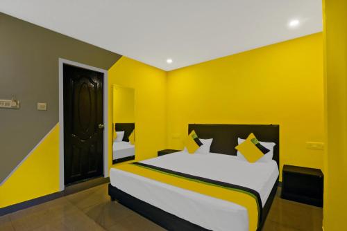 a yellow room with a bed and a black door at 29 Beach House Goa in Morjim