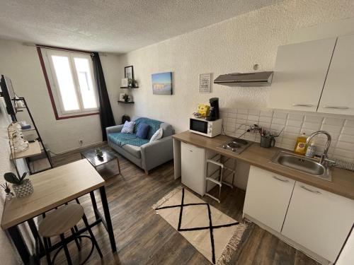 une cuisine et un salon avec un canapé et une table dans l'établissement Charmant studio à proximité du Vieux-Port, à Marseille