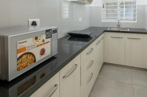 a kitchen with a box of food on the counter at Ixora Suites in Bengaluru