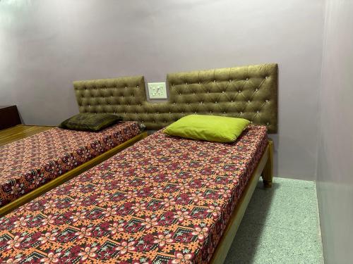 1 Schlafzimmer mit 2 Betten und einem getufteten Kopfteil in der Unterkunft New Ananda lodge in Vriddhāchalam