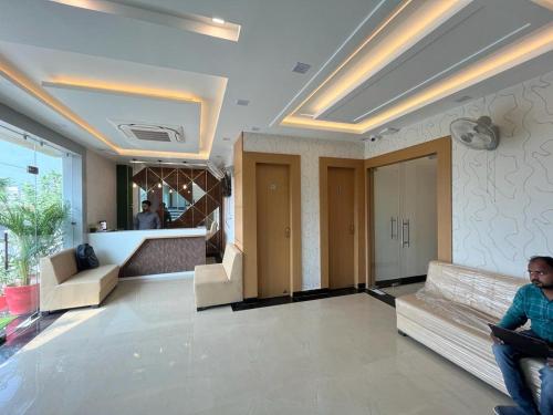 a man sitting on a couch in a hotel lobby at Hotel Royal Casa in Lucknow