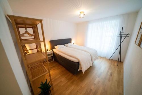 Schwändi的住宿－theCorner 2-Bedroom Apartment，一间卧室设有一张大床和一个窗户。