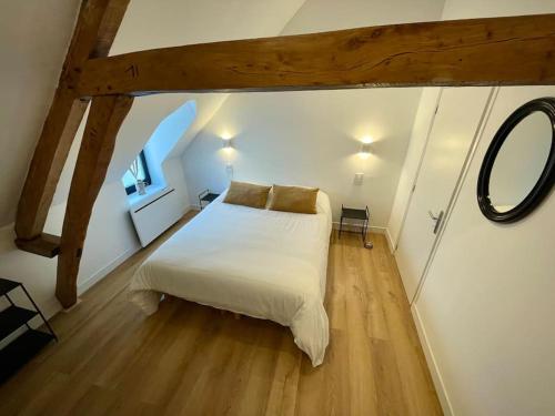 une chambre avec un grand lit blanc dans un grenier dans l'établissement La Mais'Annette, Charme et calme à 5 km du Touquet, à Étaples