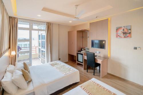 a hotel room with a bed and a desk and a television at Three Inn in Hulhumale