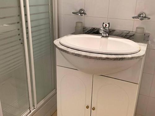 une salle de bain avec un lavabo blanc et une douche dans l'établissement Charmant T2 cabine rénové avec piscine, parking privé, proche plage et commerces - FR-1-607-91, au Cap d'Agde