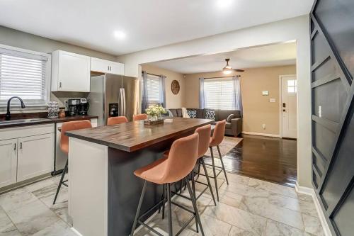 a kitchen with a large island in a kitchen with orange bar stools at Charlotte Charm Haven with Outdoor TV in Charlotte