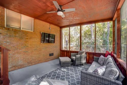 a living room with a couch and a ceiling fan at Charlotte Charm Haven with Outdoor TV in Charlotte