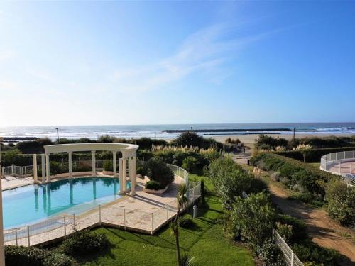 - une piscine avec un kiosque à côté d'une plage dans l'établissement Agréable T3 avec terrasse et grande piscine, à deux pas de la plage - FR-1-607-101, au Cap d'Agde