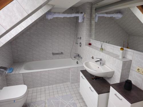 a bathroom with a sink and a tub and a toilet at -Bodensee-Cinema Feeling- Home Sharing - in Radolfzell am Bodensee