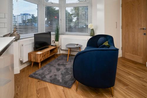 a living room with a blue chair and a television at Coppergate Mews Doncaster Apartment 3 in Doncaster