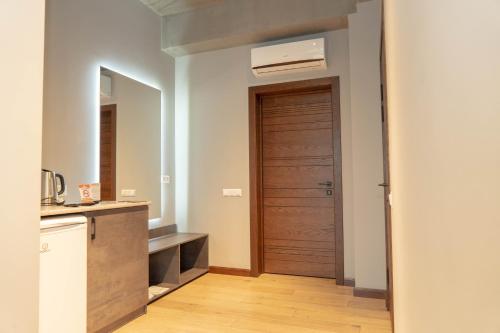 uma cozinha com uma porta de madeira e um lavatório em Gastello hotel em Bishkek