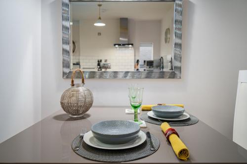 una mesa con platos, gafas y espejo en Coppergate Mews Apartment Doncaster 3, en Doncaster