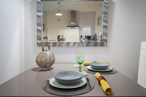 a table with plates and glasses and a mirror at Coppergate Mews Doncaster Apartment 3 in Doncaster