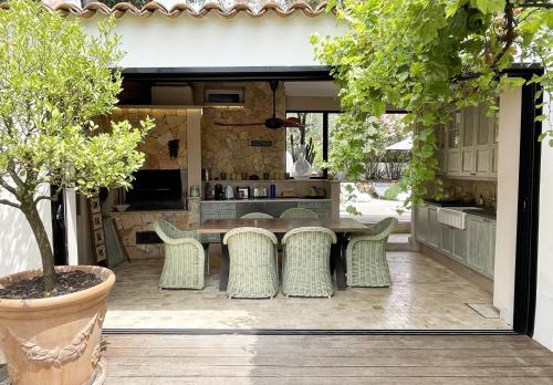 un patio avec une table et des chaises et une cuisine dans l'établissement VILLA CANZOMY, à Saint-Paul-de-Vence