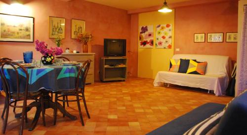 a living room with a table and a bed at Case Vacanze Fossanave in Santa Tecla