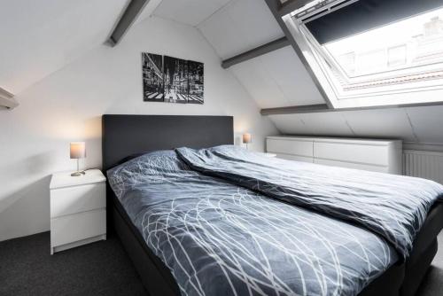 een slaapkamer met een groot bed en een dakraam bij Vakantiehuisje aan de Kust - nr 33 in Egmond aan Zee