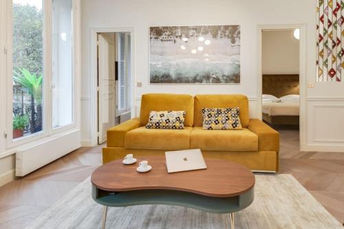 un salon avec un canapé et une table dans l'établissement Bright and Gorgeous flat in the heart of Paris, à Paris