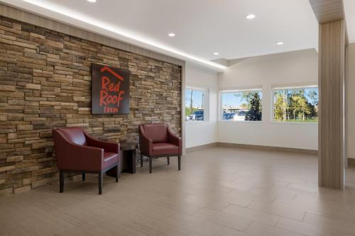a waiting room with chairs and a brick wall at Red Roof Inn Sulphur in Sulphur