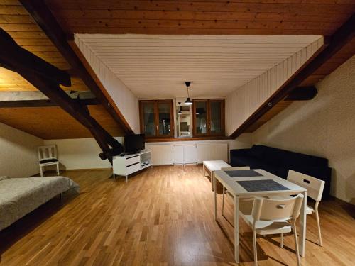 a attic room with a bed and a table and chairs at Studio au centre de Genève in Geneva