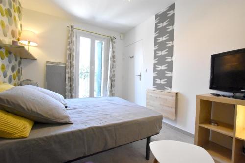 une petite chambre avec un lit et une télévision dans l'établissement Coquet studio centre historique et au calme (4), à Montpellier