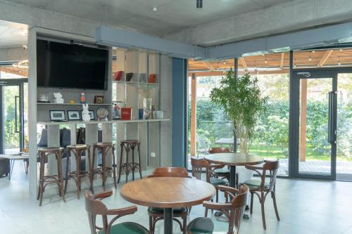 a dining room with tables and chairs and a tv at Gastello hotel in Bishkek