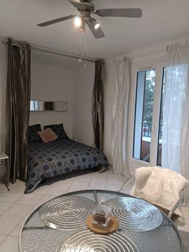 Cette chambre comprend une table, un lit et une fenêtre. dans l'établissement joli studio design balcon sud et parking gratuit, à La Garde