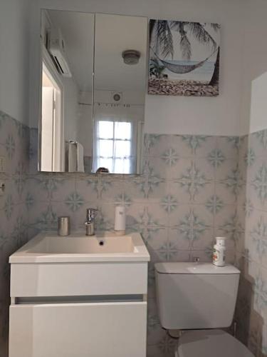 une salle de bain avec un lavabo, des toilettes et un miroir dans l'établissement joli studio design balcon sud et parking gratuit, à La Garde