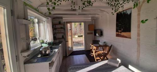 una habitación vacía con una mesa y una cocina en una casa en La Rikiki du petit ruisseau, en Mandeville