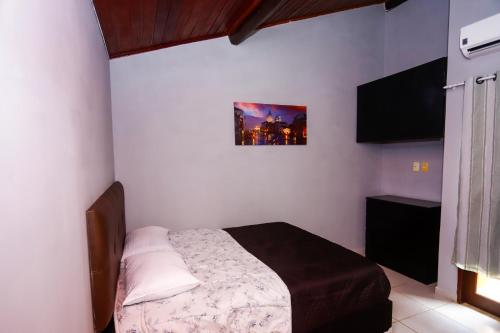1 dormitorio con 1 cama y una foto en la pared en Winterville Gravatá Flat 425 - Próximo das piscinas en Gravatá
