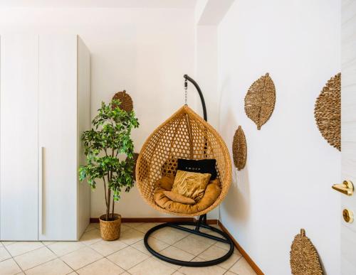 una silla colgante en una habitación con una planta en Wonderful Double Rooms - Comfort in CityLife- near METRO - FREE PARKING, en Milán