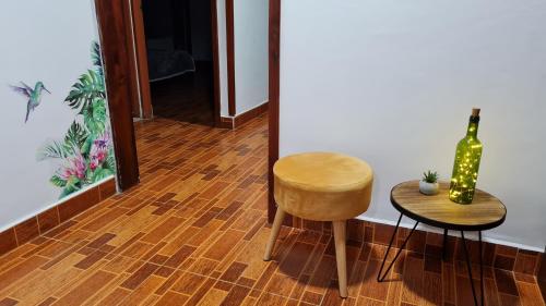 a room with a chair and a bottle of wine at Casa Selah - Una pausa entre café y montañas in Salento