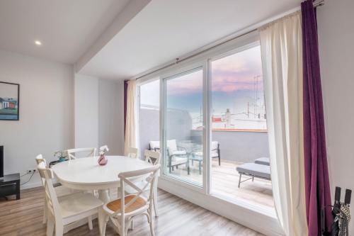 a dining room with a table and a large window at Modern Penthouse with Private Terrace in Valencia