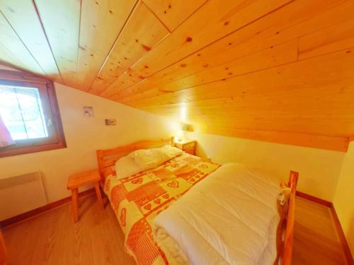 un lit dans une chambre avec un plafond en bois dans l'établissement Charmant Appartement Familial 2 Pièces avec Mezzanine, Balcon et Proximité des Pistes - Hauteluce - FR-1-594-93, à Hauteluce
