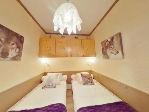 - 2 lits dans une chambre avec des photos sur le mur dans l'établissement Charmant 2 pièces aux Saisies, balcon sud-ouest, centre station, 4 pers., classé 2 étoiles - FR-1-594-139, à Hauteluce